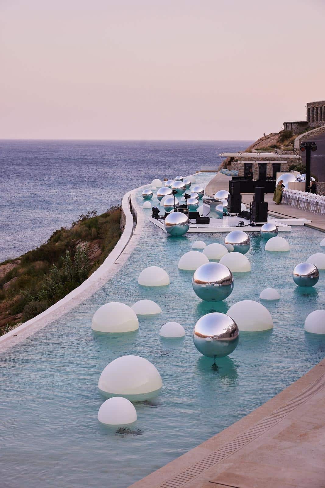 Chrome LED orbs reflecting in infinity pool at night in Mykonos — private event via 8 The Agency — Out of Thin Air